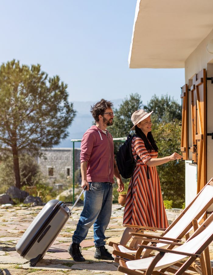 Due turisti con valigia entrano in una casa vacanza a Roma per il check-in